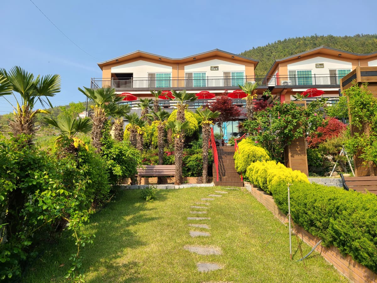 하늘빛바다펜션 봄 저녁 정원 중앙 잔디길을 따라 보이는 펜션 객실동 전경